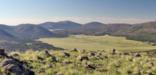 View of an oval, grassy area--the caldera--surrounded by mountains.